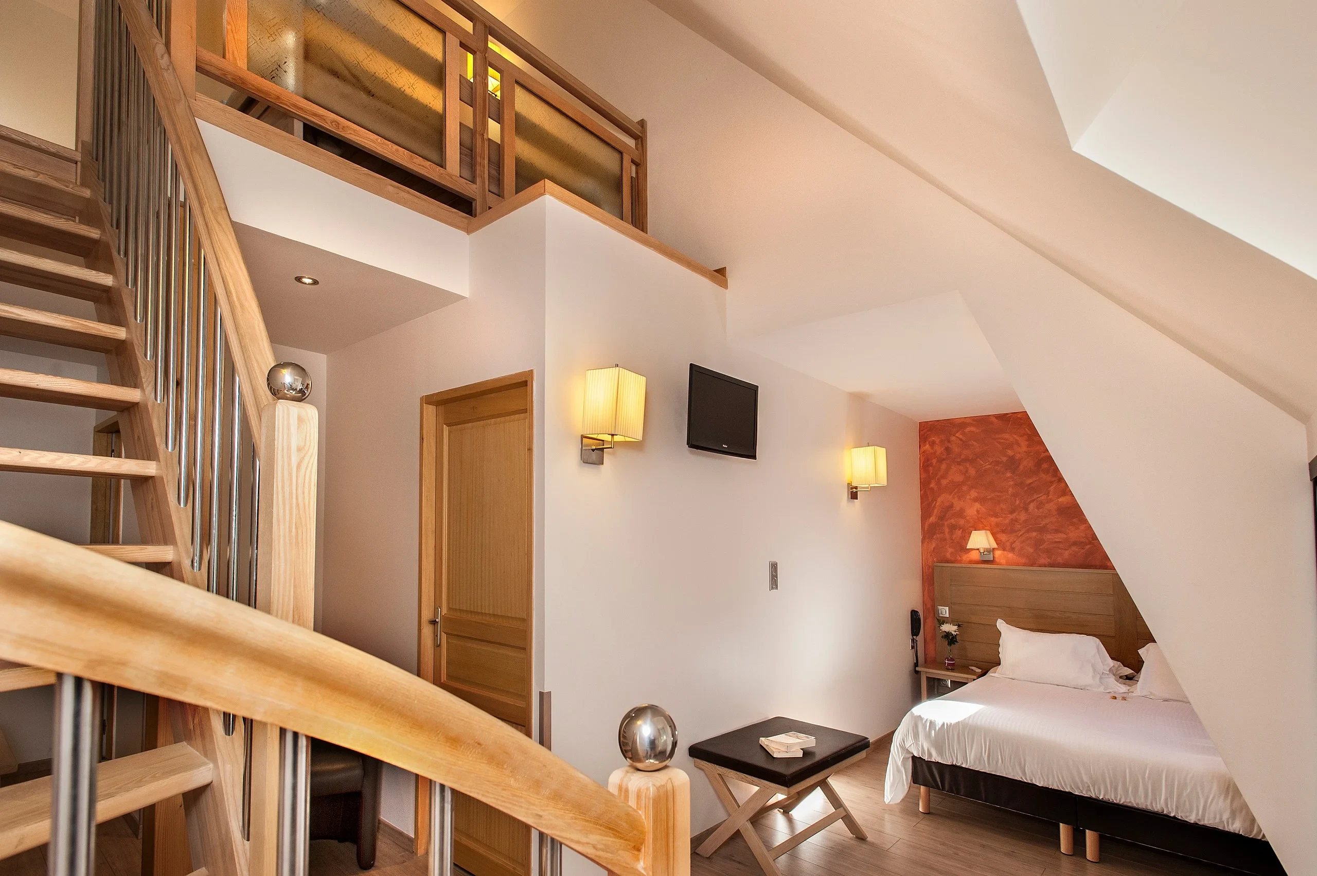Chambre moderne avec lit et escalier en bois