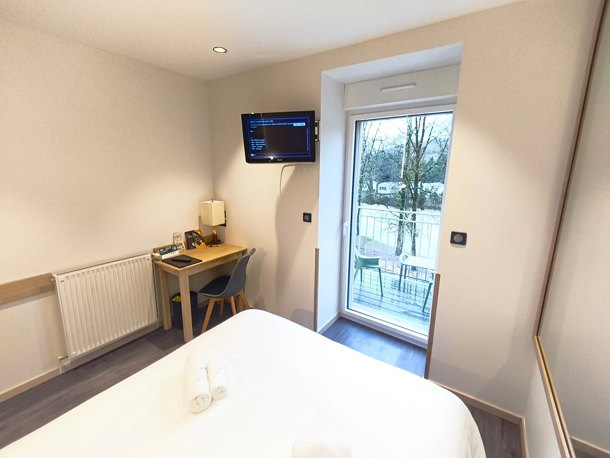 Chambre avec lit, bureau et balcon