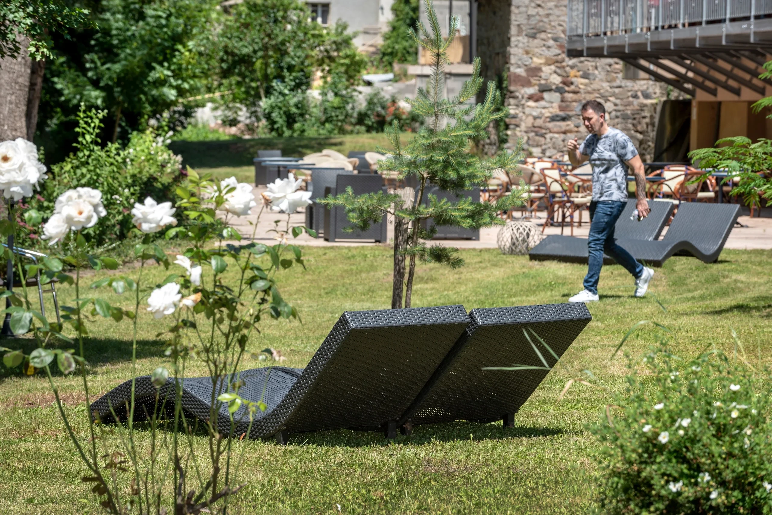 Jardin avec chaises longues et homme marchant