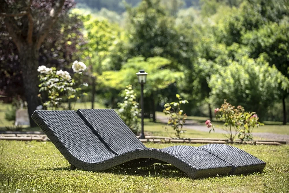Transats noirs en osier dans un jardin verdoyant