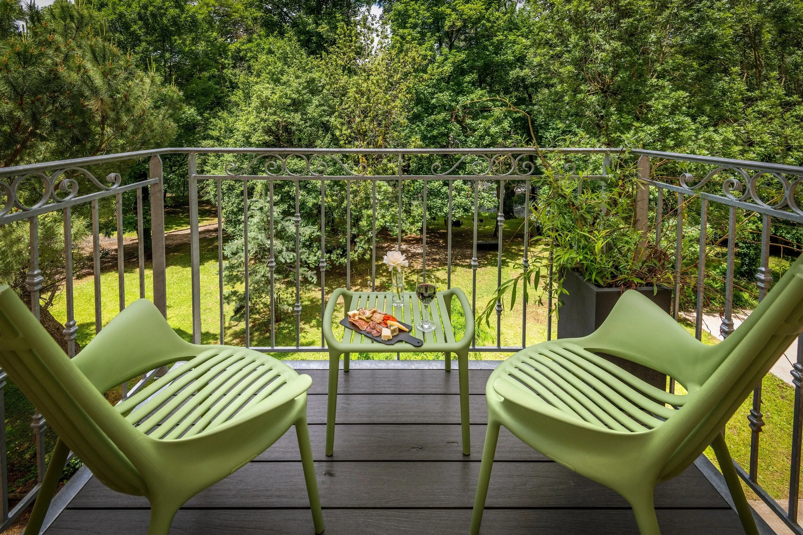 Terrasse avec chaises vertes et vue sur jardin
