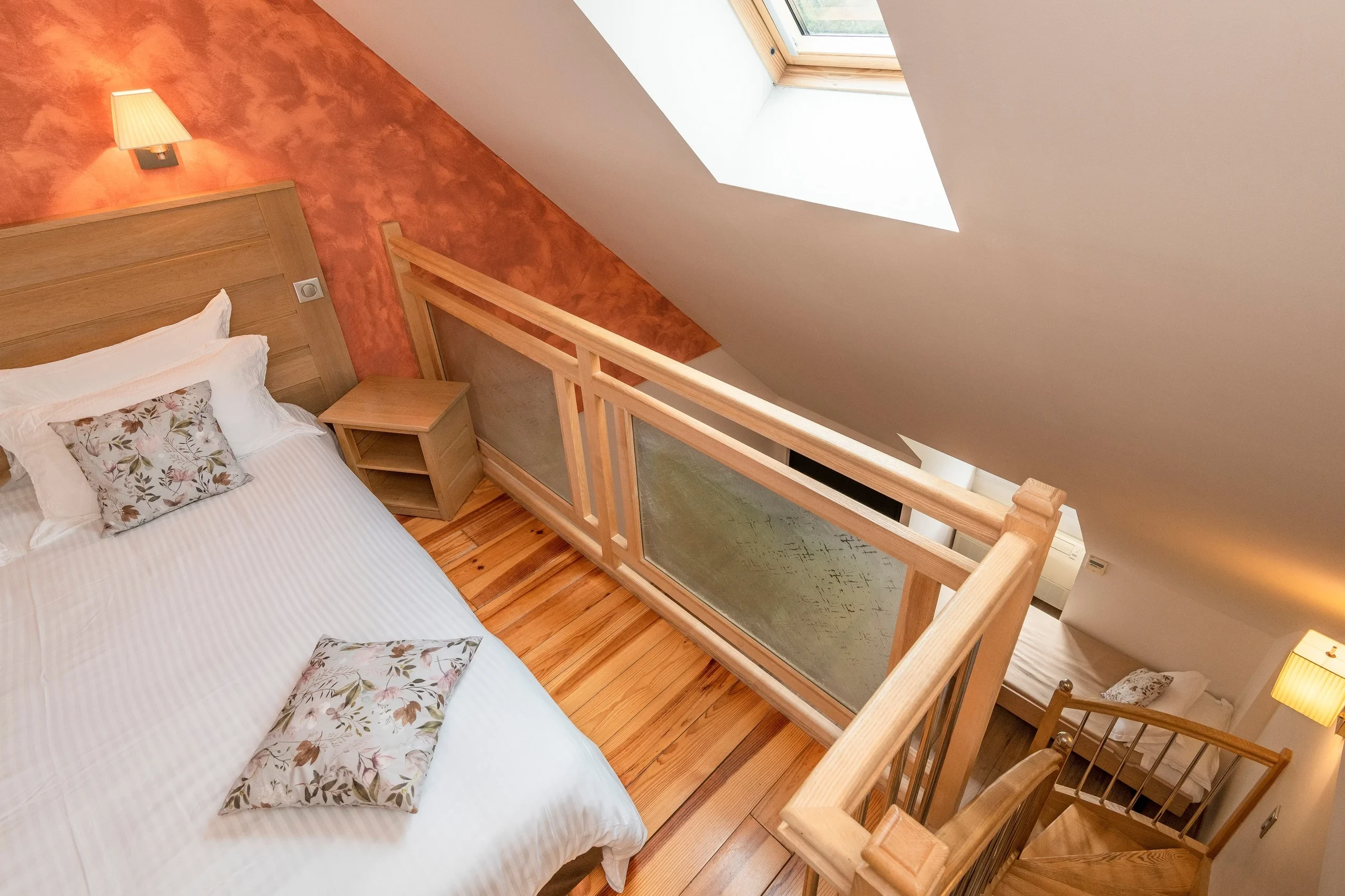Chambre avec lit et mezzanine en bois clair